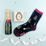 Mini Luxury celebration box, includes a mini bottle of Moet, press for champagne chocolates and a pair or glittery champagne socks.