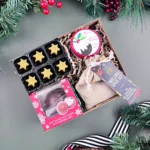 The Christmas Mini Hamper Gift Box – festive gift set with 3 delicious Christmas treats and a candle: chocolate Christmas pudding truffles with rum, Belgian hot chocolate bauble with marshmallows, mulled wine and spiced cider kit, and a figgy pudding scented candle – luxury Christmas hamper gift for him, her, family, or friends.