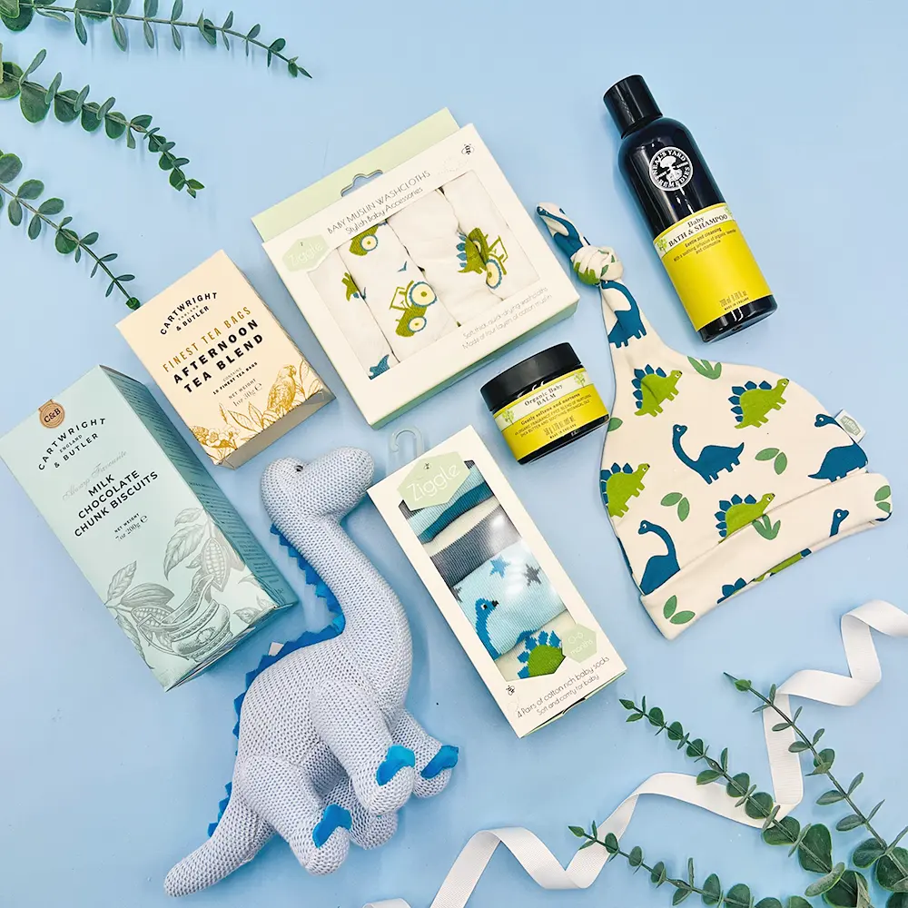 New baby boy gift hamper with dinosaur rattle and baby essentials