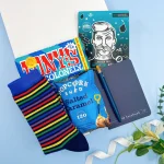 Letterbox gift for him featuring striped socks, popcorn, notebook and face mask