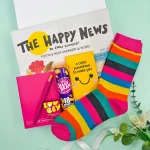 Bright rainbow letterbox gift with colourful socks, sweets, notebook and positive newspaper